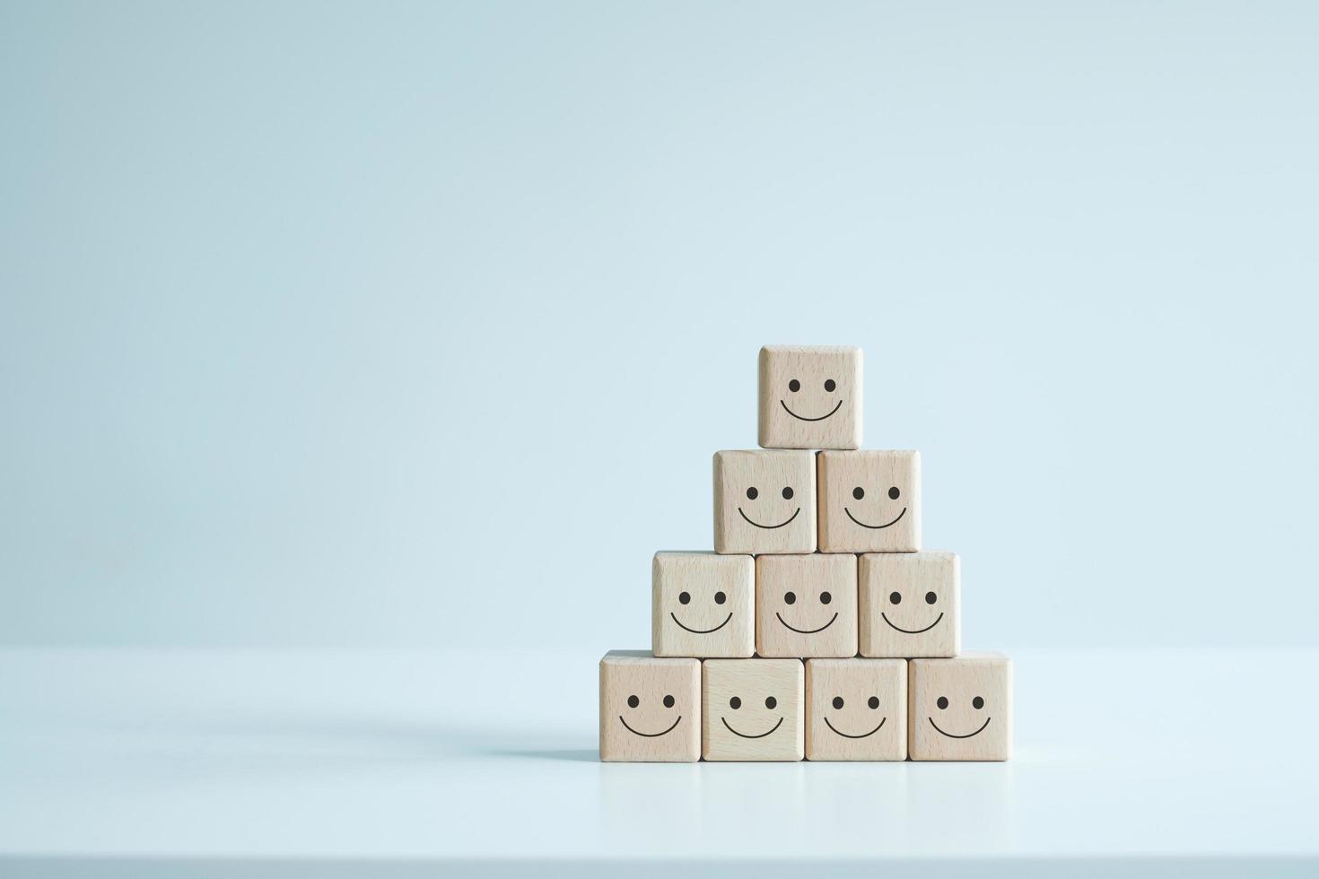 ícones de rosto sorridente em cubos de madeira. classificação de serviço de negócios, satisfação do cliente ou conceito de trabalho em equipe. foto