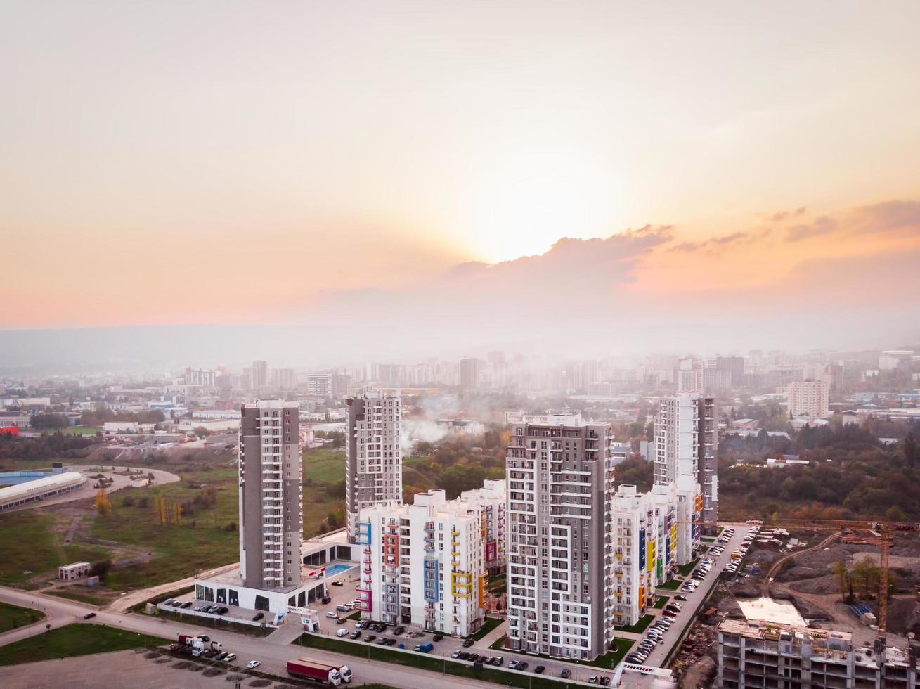 tbilisi, geórgia, 2021 - vista aérea complexo de apartamentos diamante complexo de edifícios imobiliários altos nos subúrbios da cidade com céu nebuloso poluído e fundo por do sol foto