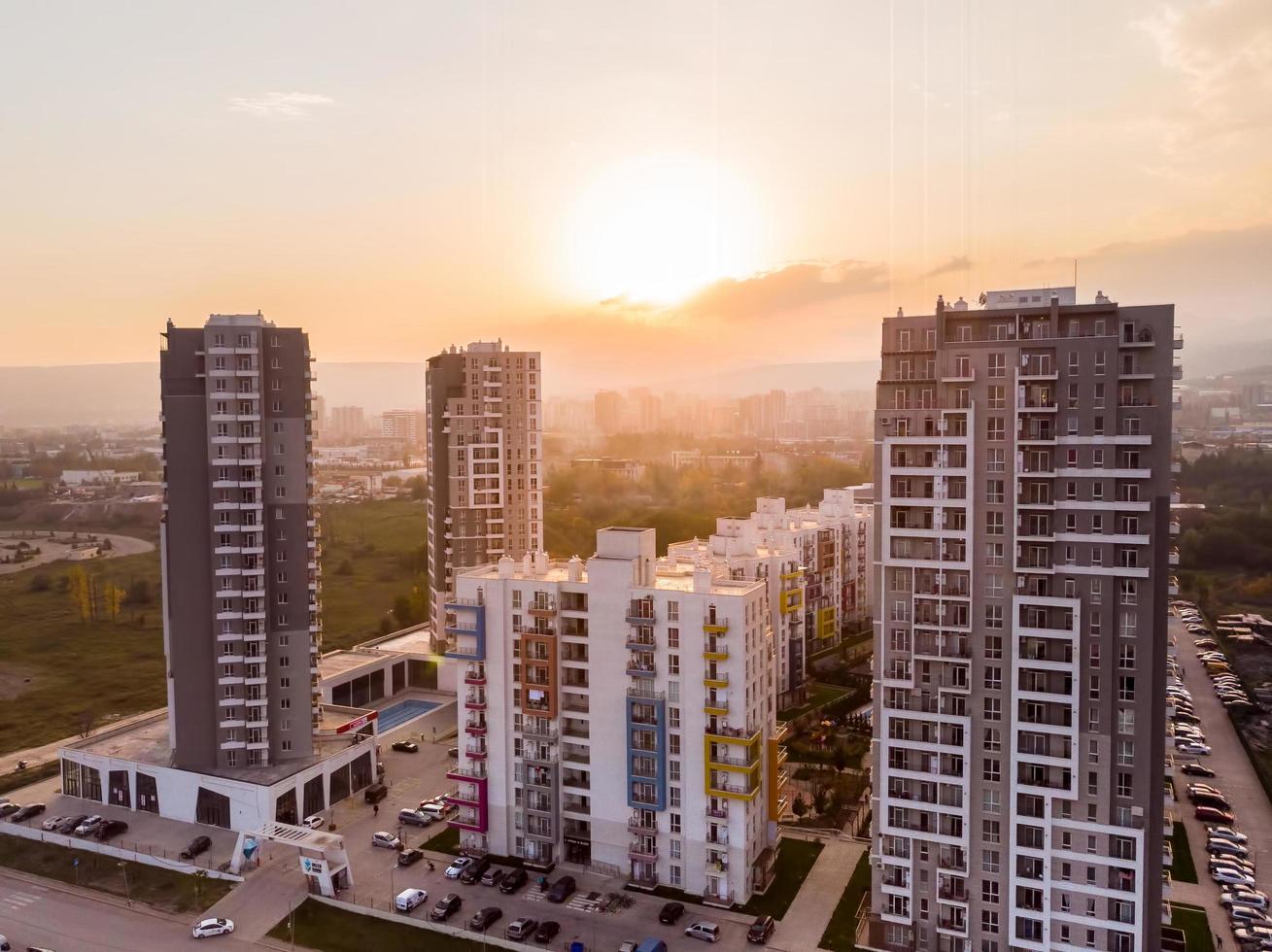 tbilisi, geórgia, 2021 - panorama de edifícios complexos de apartamentos de diamante verde com fundo ensolarado por do sol. conceito de indústria de negócios imobiliários da geórgia foto