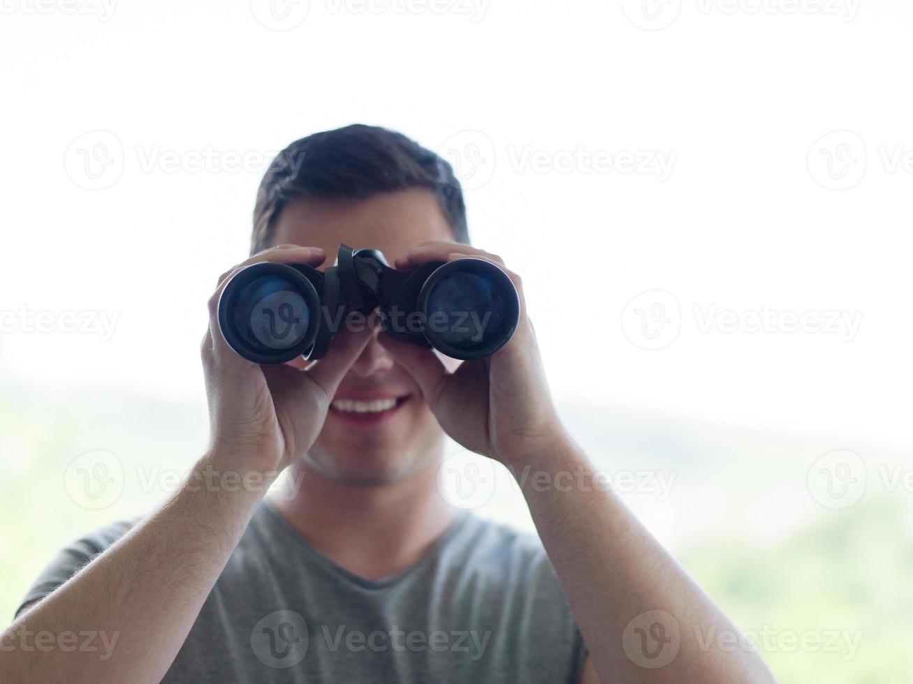 homem olhando com binóculos foto