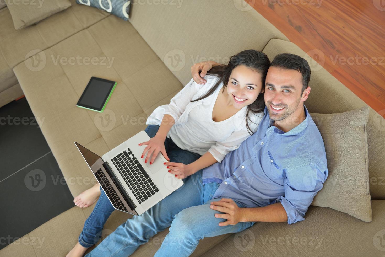 jovem casal usando laptop em casa foto