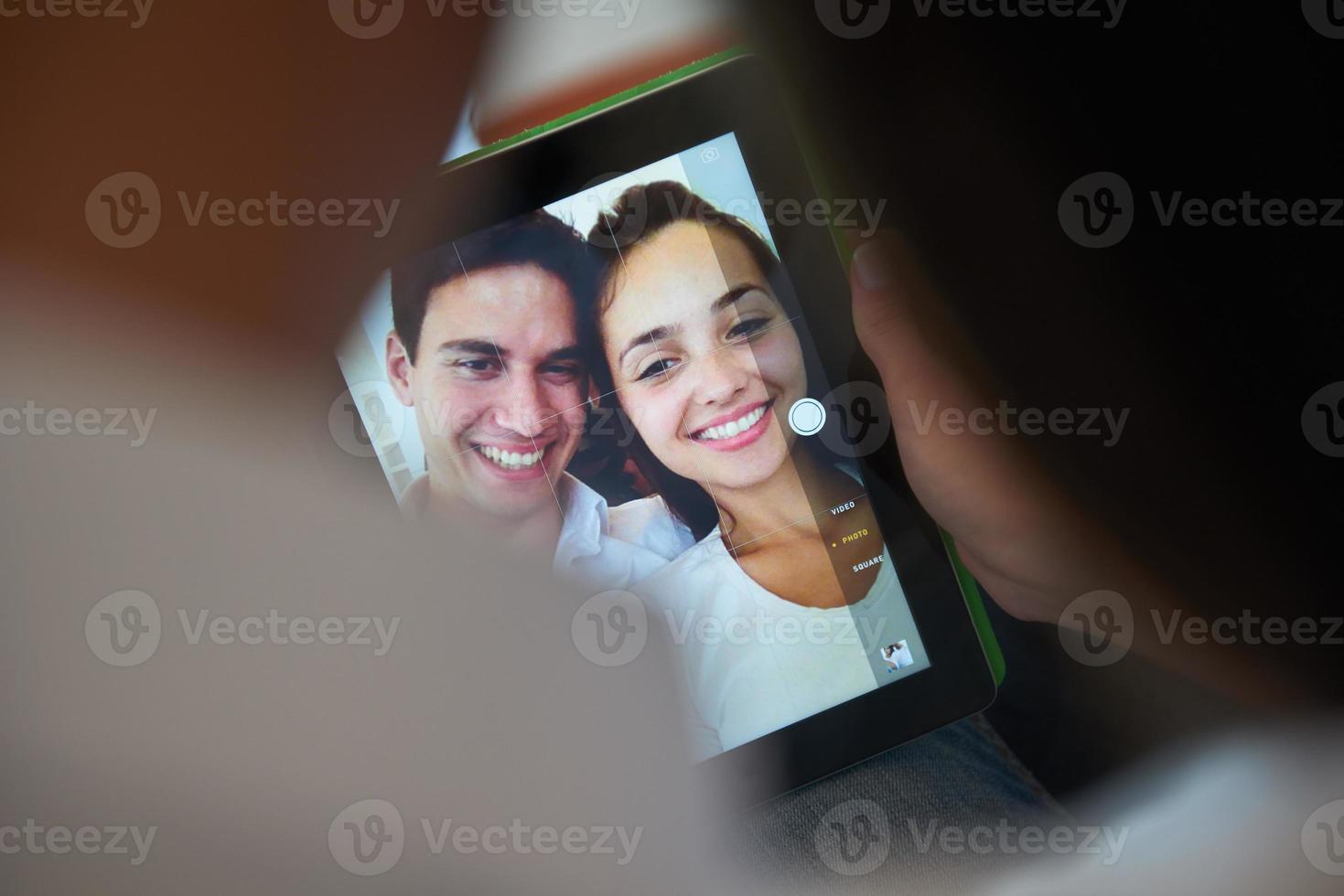 casal em casa moderna usando computador tablet foto