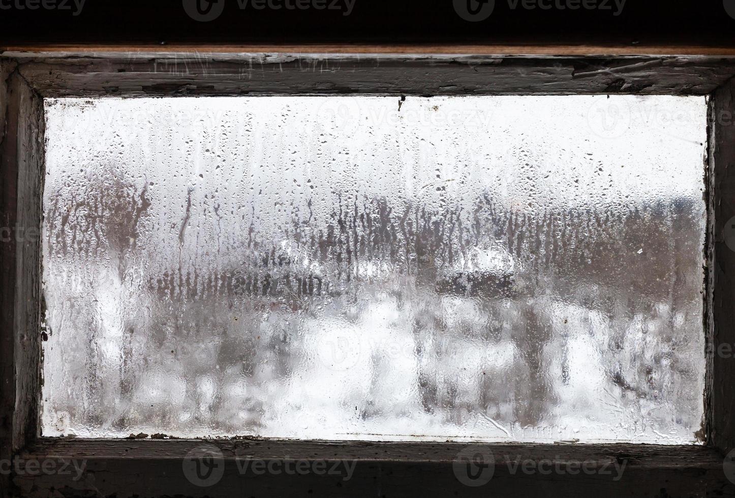 gotas de água na janela congelada enevoada da casa rural foto