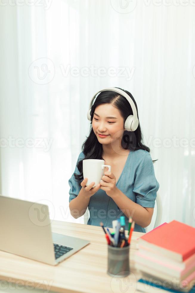 Menina asiática inteligente trabalho remoto laptop relógio seminário bebida caneca de bebida em casa dentro de casa foto