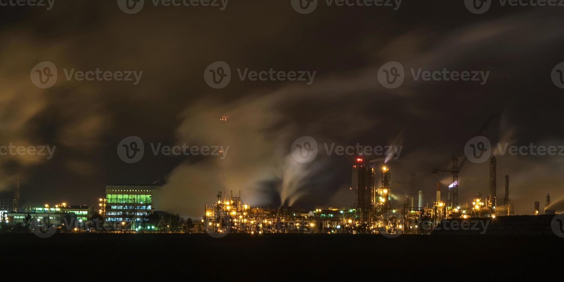 noite paisagem industrial poluição ambiental resíduos de usina termelétrica. grandes tubos da planta da empresa da indústria química foto