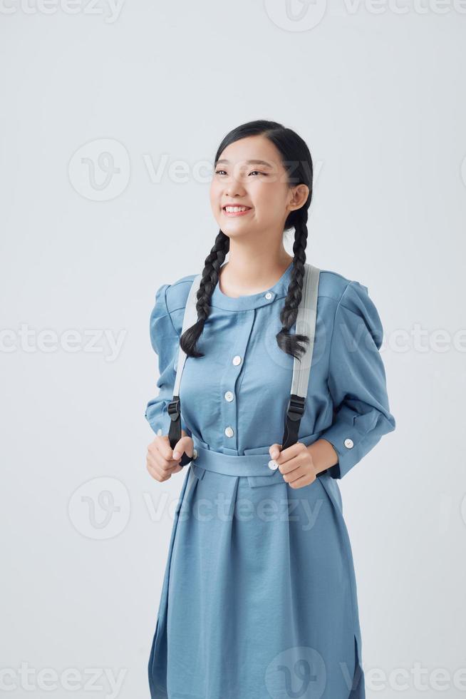 atraente jovem aluna com uma mochila cinza por cima do ombro foto