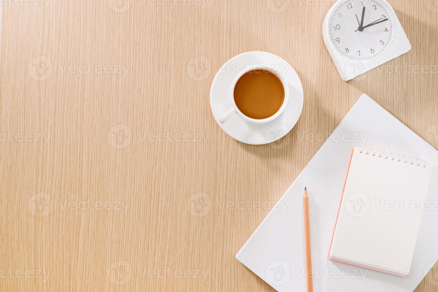 postura plana de xícara de café, relógio, lápis e um caderno. foto