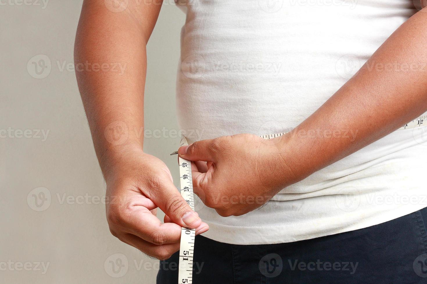 medir a gordura ao redor do homem gordo da barriga. foto