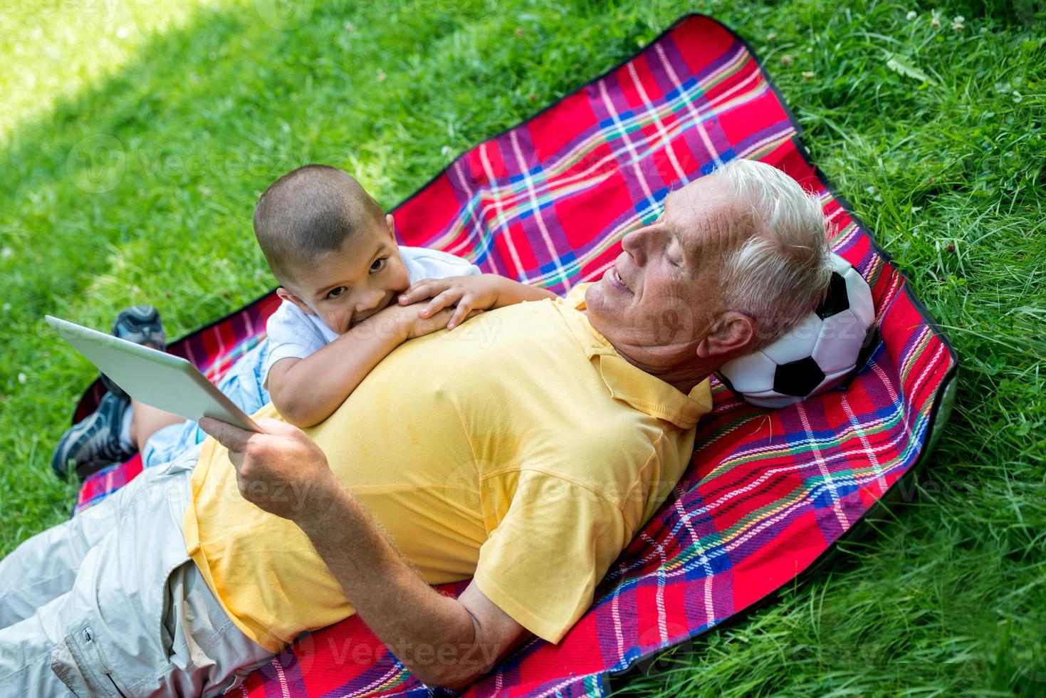 avô e filho no parque usando tablet foto