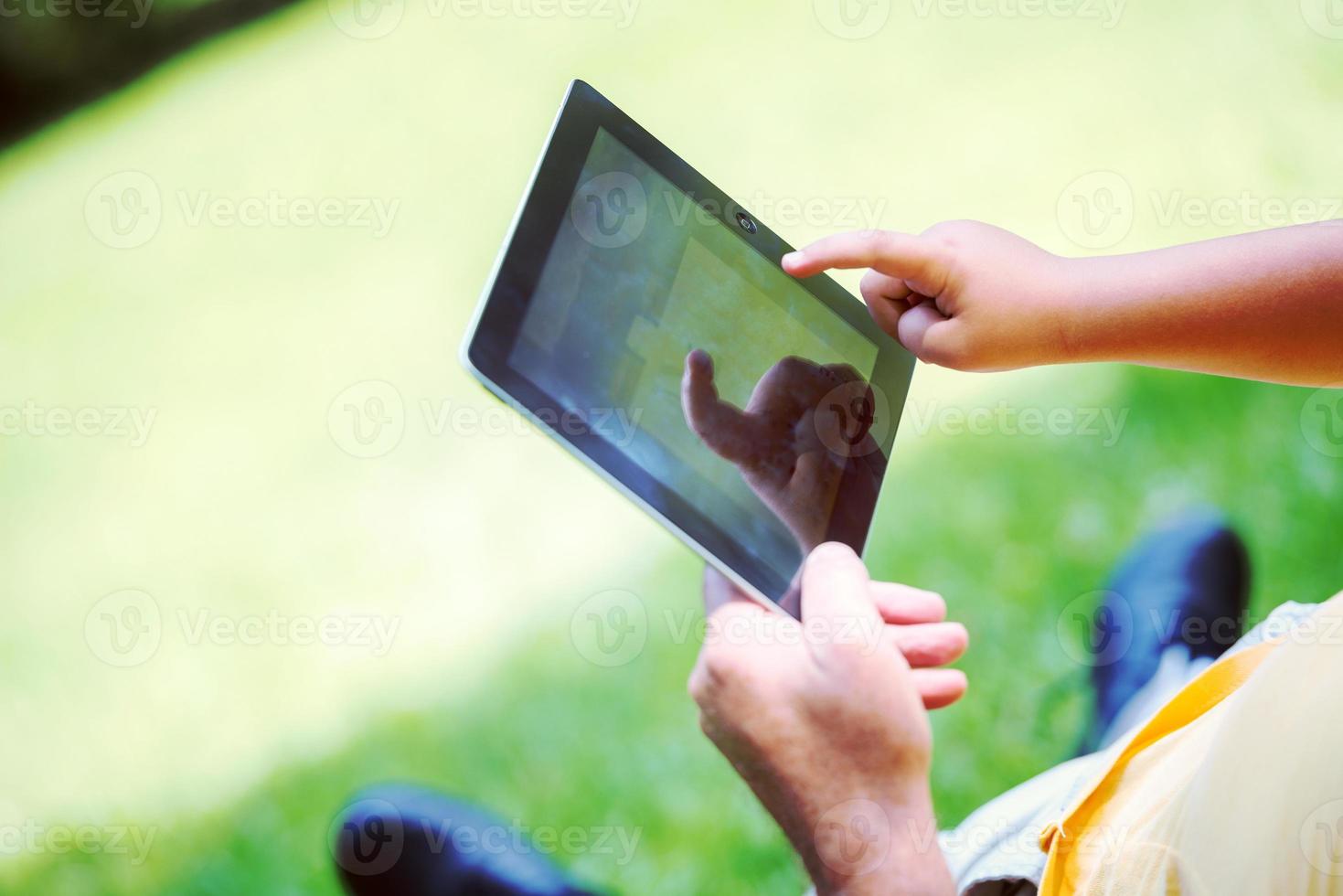 avô e filho no parque usando tablet foto