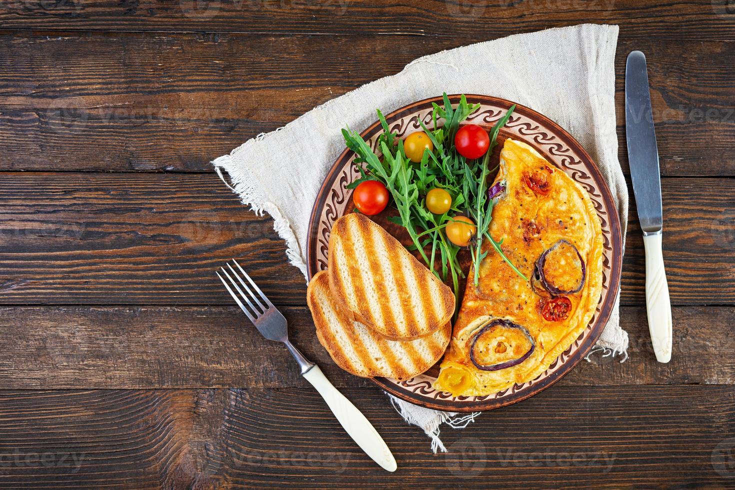 omelete com tomate, cebola, queijo e ervas. saborosa omelete de café da manhã. vista do topo foto