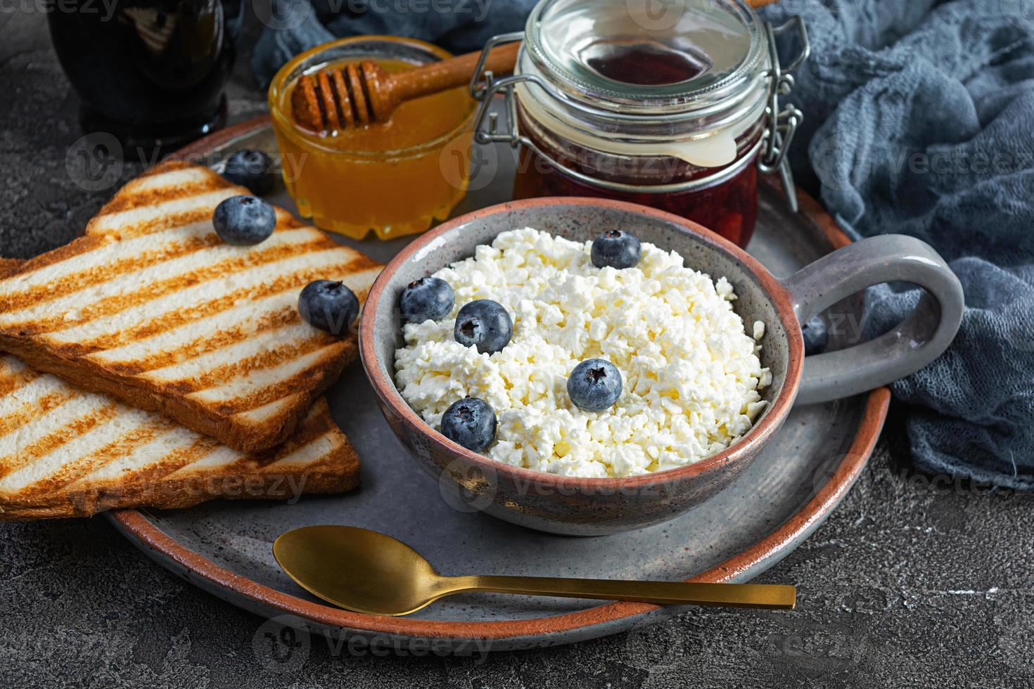 delicioso requeijão com mirtilo, mel, geléia de morango e torradas. café da manhã saudável foto