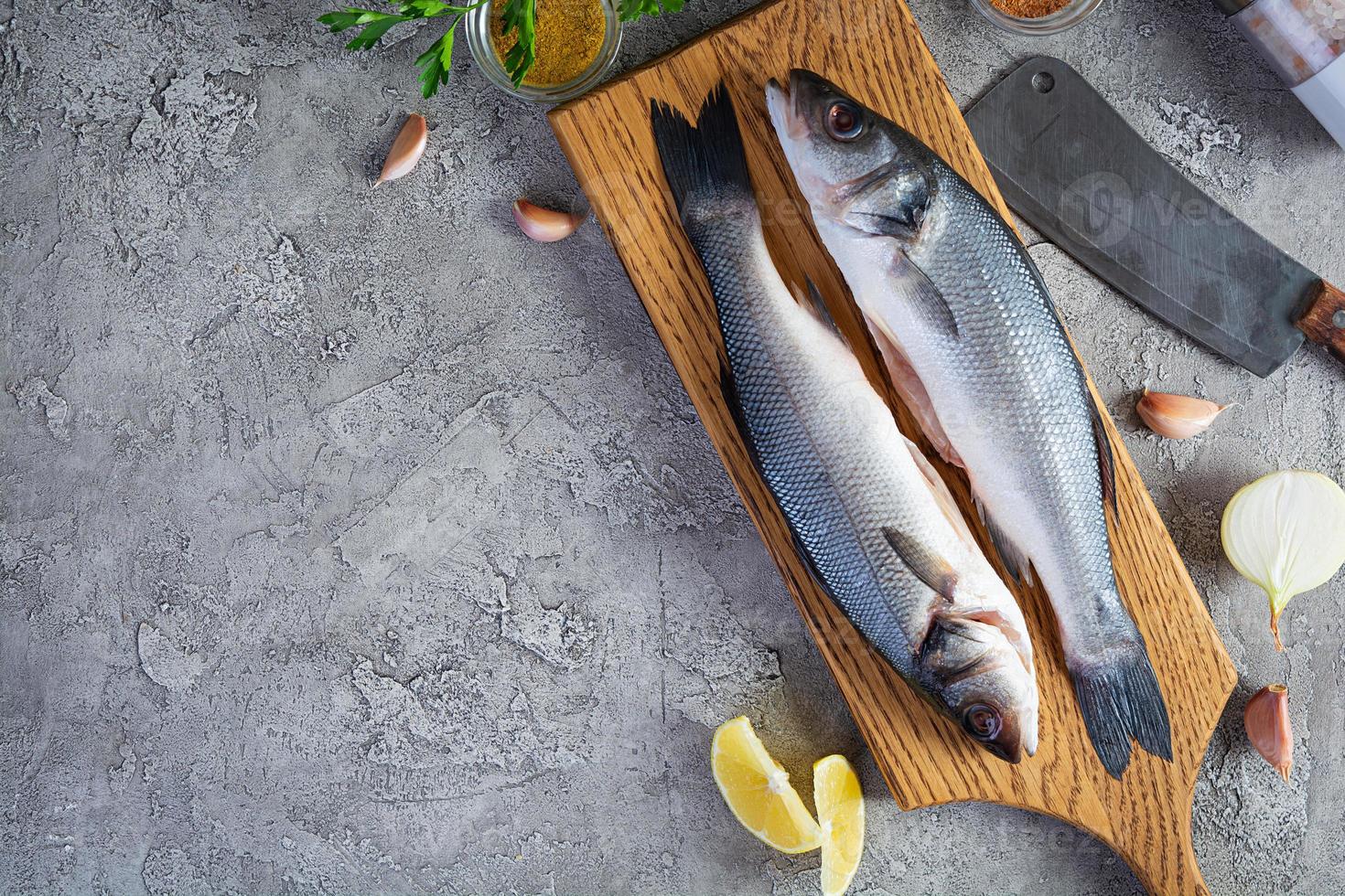 robalo fresco cru com especiarias diferentes na tábua. vista do topo foto