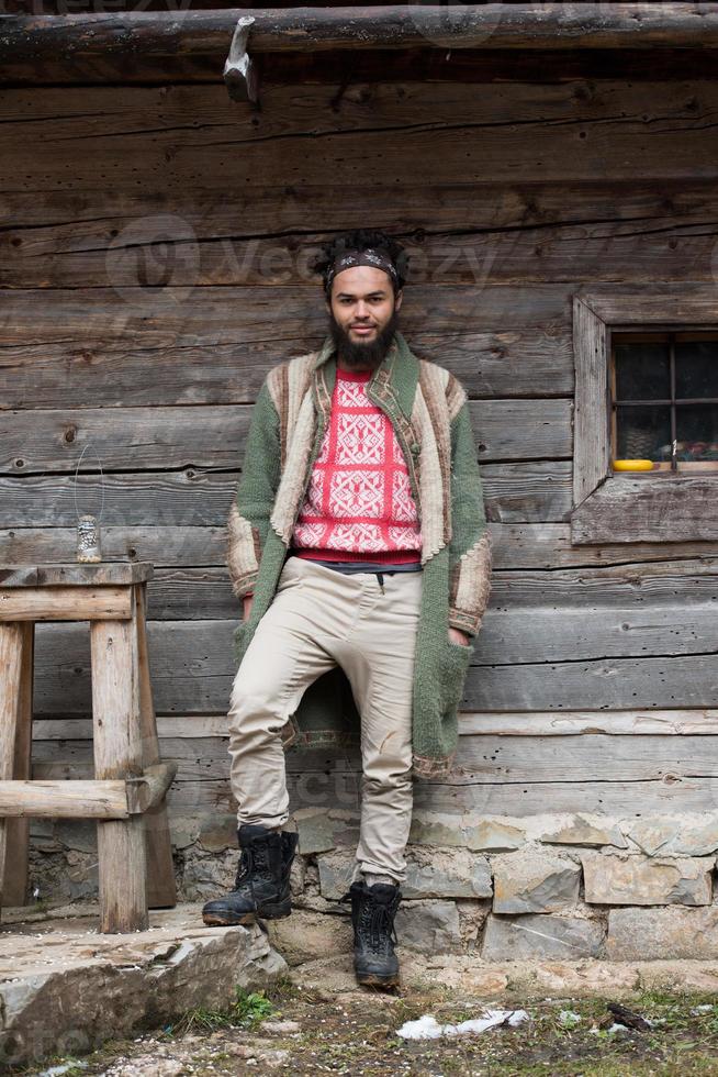 retrato de jovem hipster na frente da casa de madeira foto