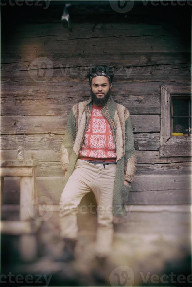 retrato de jovem hipster na frente da casa de madeira foto