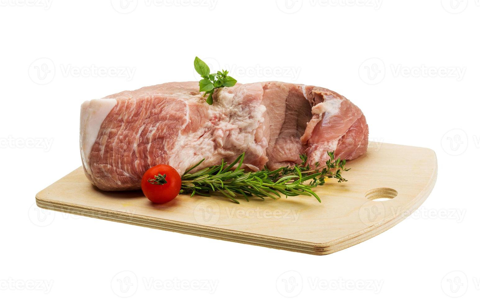 carne de porco crua na placa de madeira e fundo branco foto