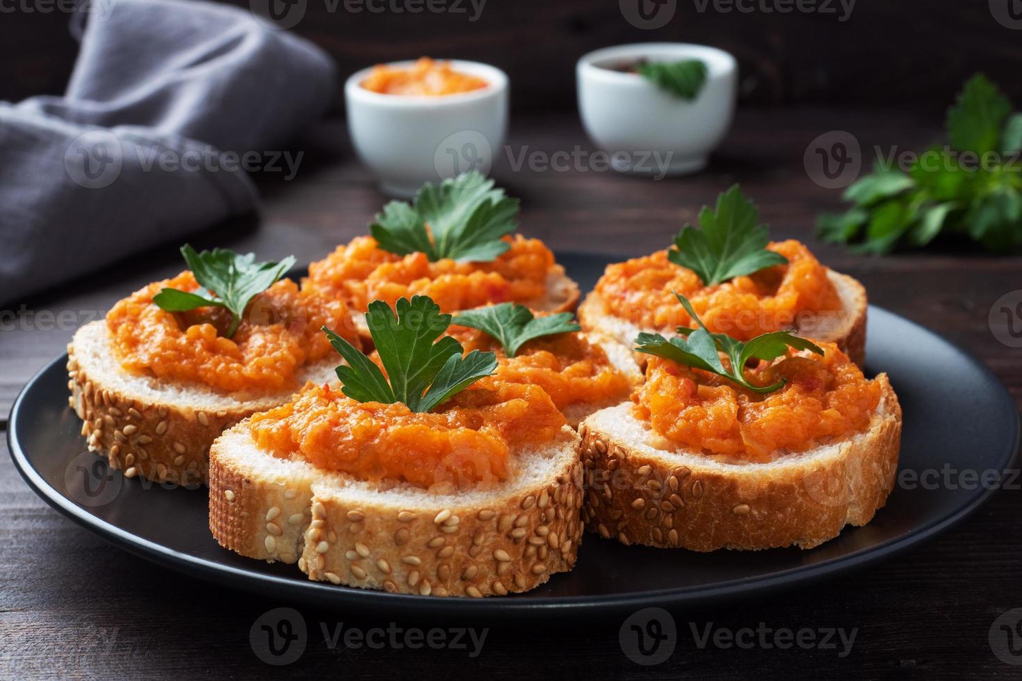 sanduíches com pão abobrinha caviar tomate cebola. comida vegetariana caseira. legumes cozidos enlatados. fundo de madeira de perto foto