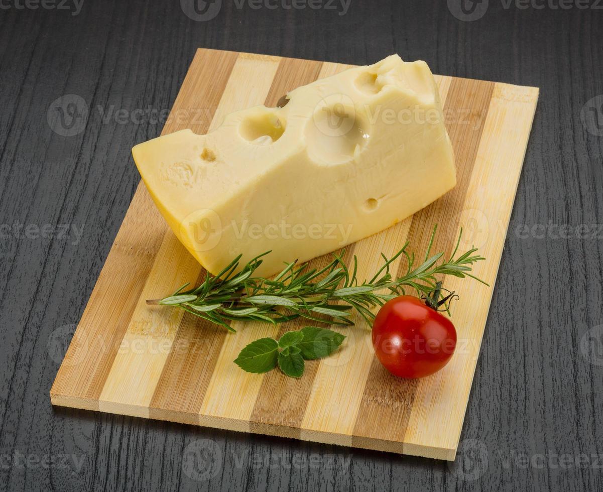 queijo maasdam em fundo de madeira foto