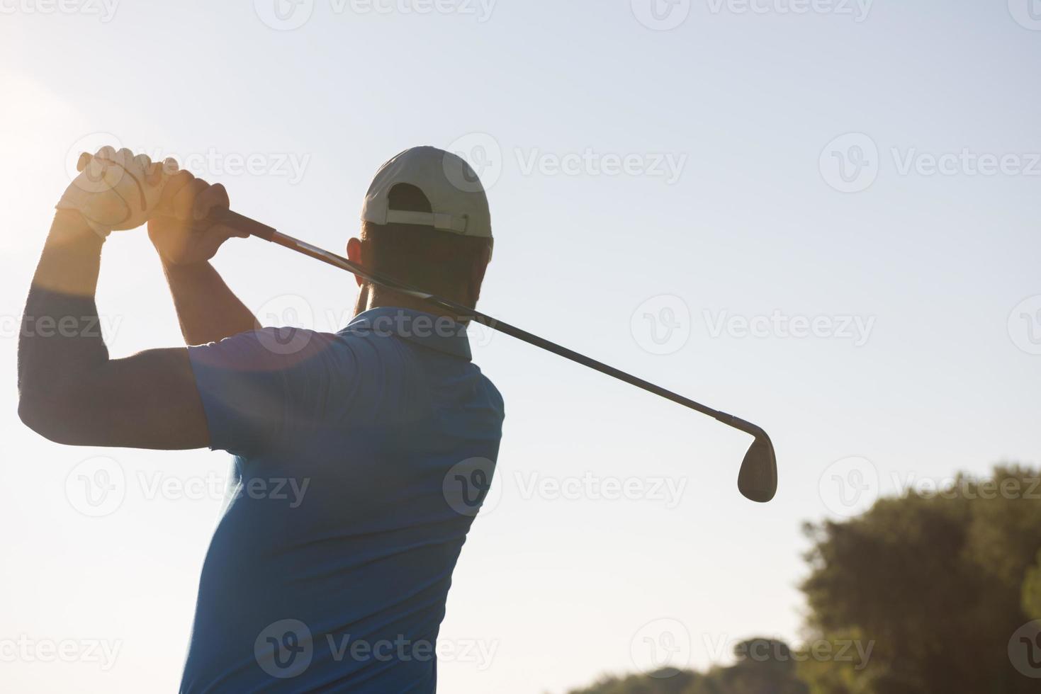 jogador de golfe acertando tiro foto
