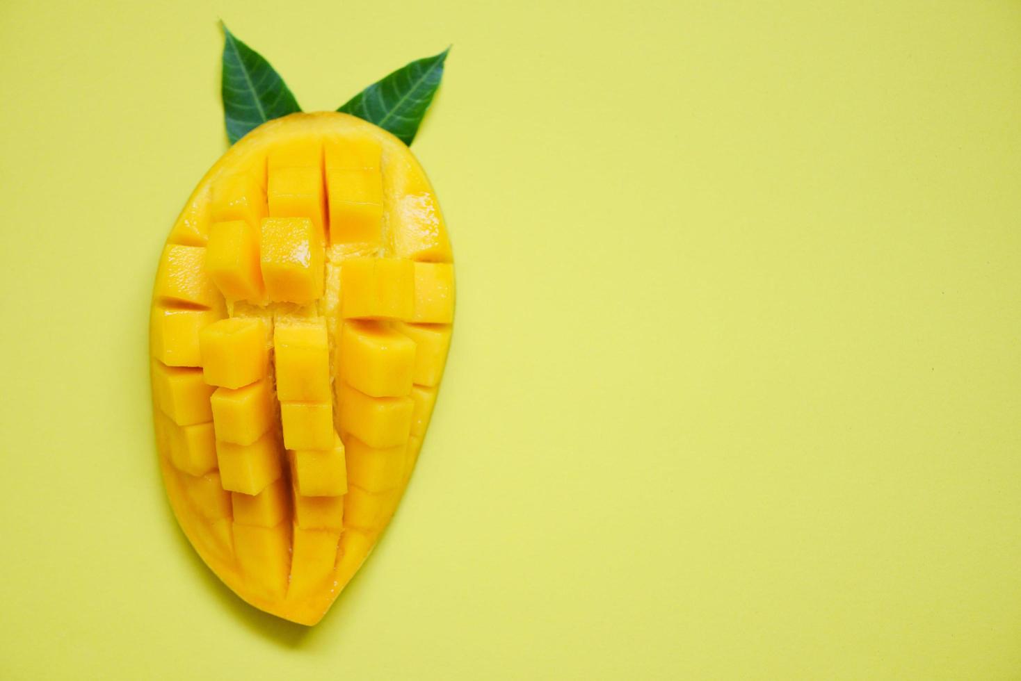 fatia de manga e folhas de manga da árvore conceito de frutas tropicais de verão mangas maduras doces cortadas ao meio foto