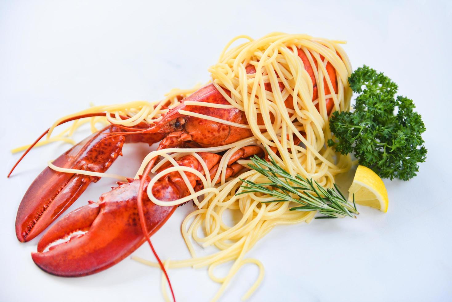 comida de lagosta de frutos do mar espaguete em um prato branco com especiarias de ervas alecrim limão servido mesa no restaurante comida gourmet lagosta cozida saudável salada cozida camarão espaguete foto