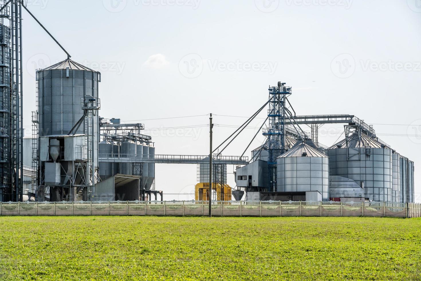 elevador de celeiro moderno. silos de prata em agro-processamento e planta de fabricação para processamento de secagem, limpeza e armazenamento de produtos agrícolas, farinhas, cereais e grãos. linha de limpeza de sementes foto