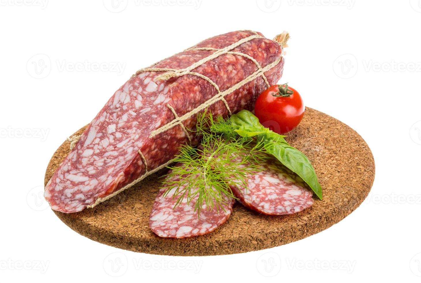 salame na placa de madeira e fundo branco foto