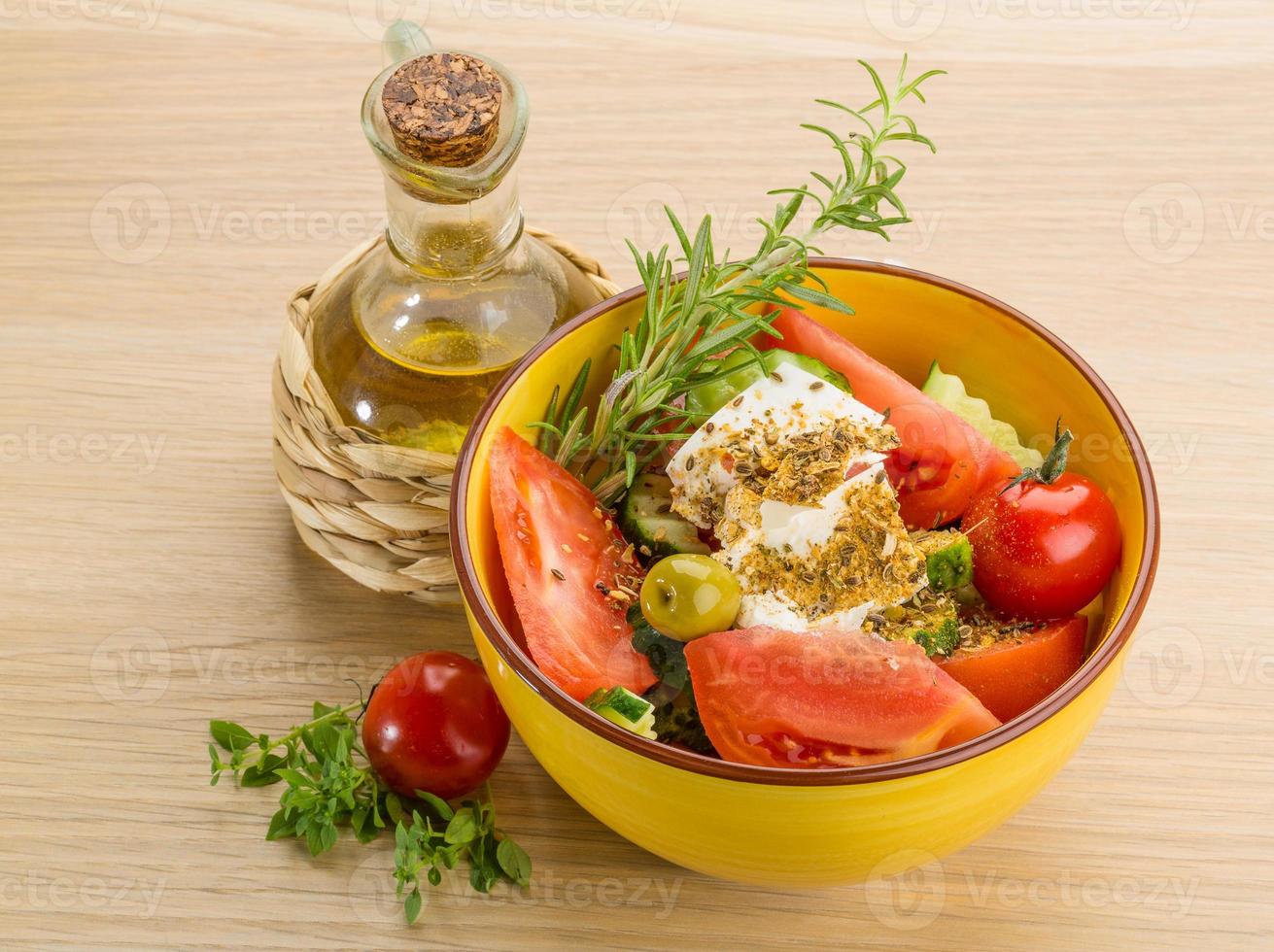 salada grega em uma tigela sobre fundo de madeira foto