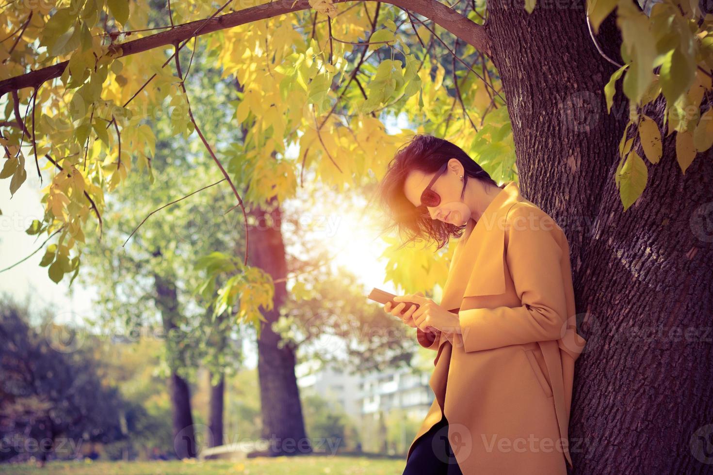 mulher bonita usando telefone celular no parque. foto