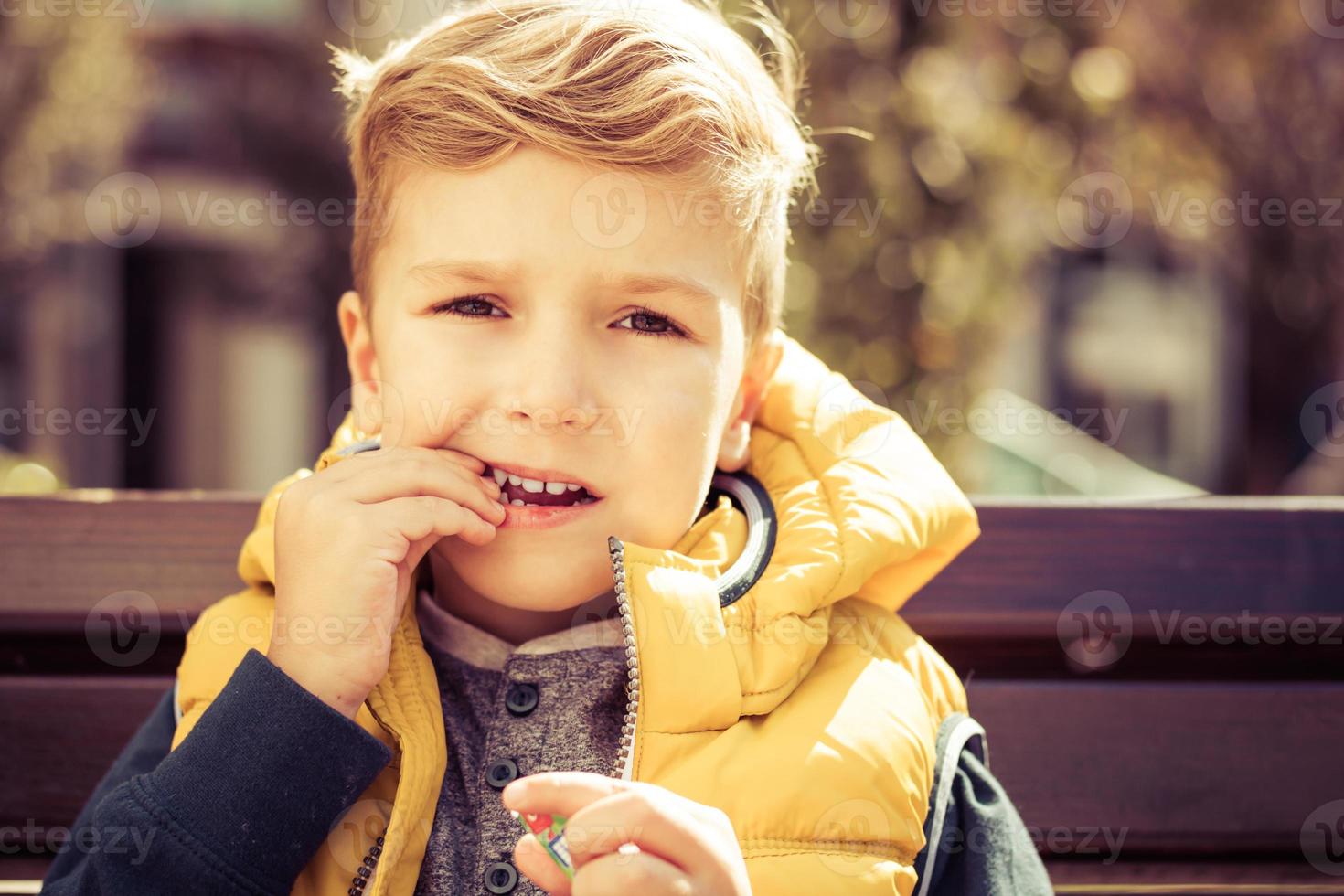 lindo garoto comendo doces ao ar livre. foto