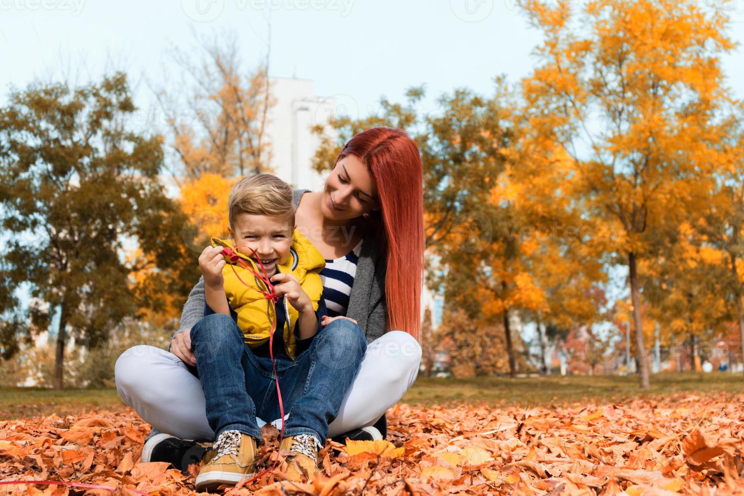 feliz mãe e filho durante o dia de outono no parque. foto