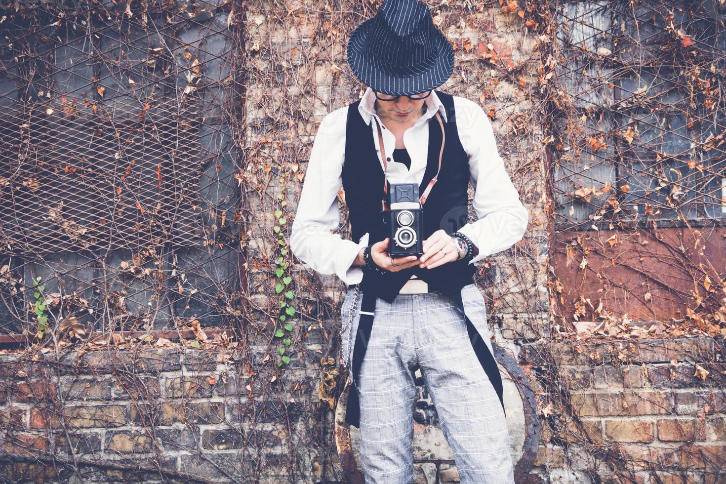 homem de estilo retrô tirando foto com câmera fotográfica vintage.