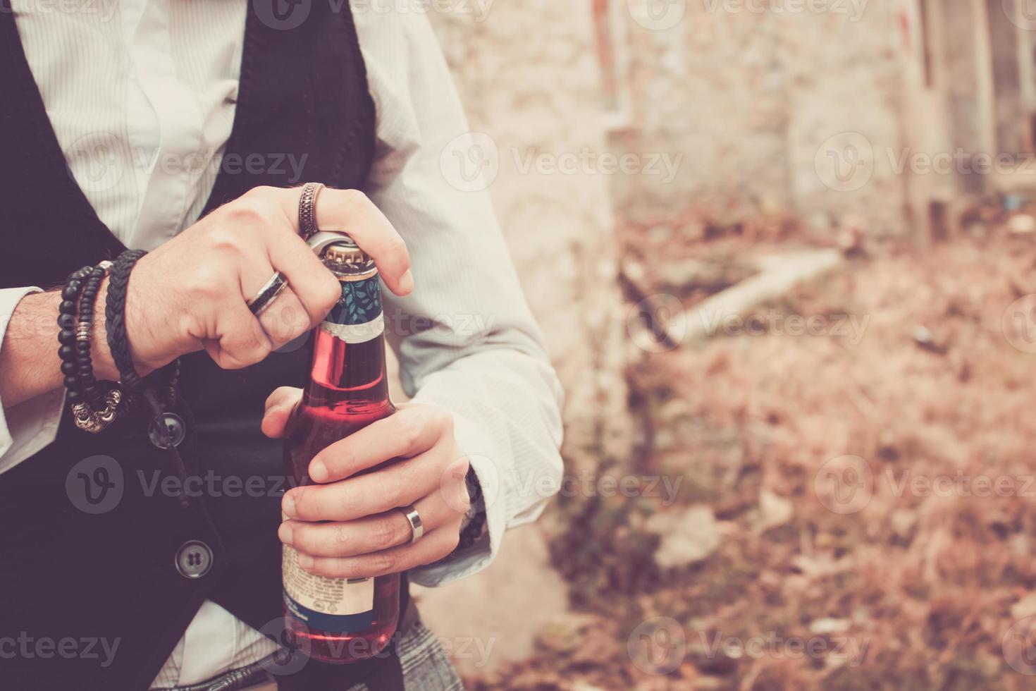 homem irreconhecível abrindo a garrafa de cerveja. foto