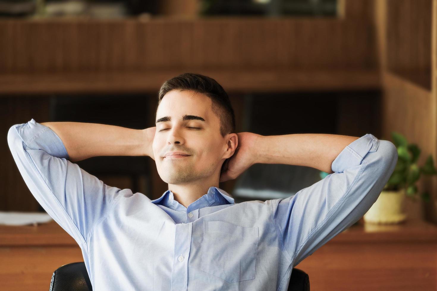 gerente de marketing masculino descansando e sorrindo enquanto trabalhava para reduzir a sonolência. foto