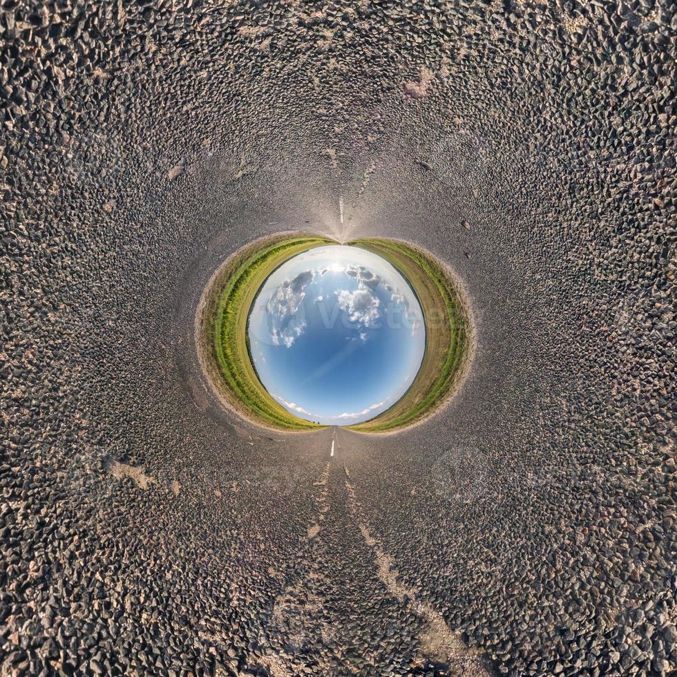 bola de céu azul no meio da estrada de asfalto ou campo. inversão do pequeno planeta transformação do panorama esférico 360 graus. visão abstrata esférica. curvatura do espaço. foto