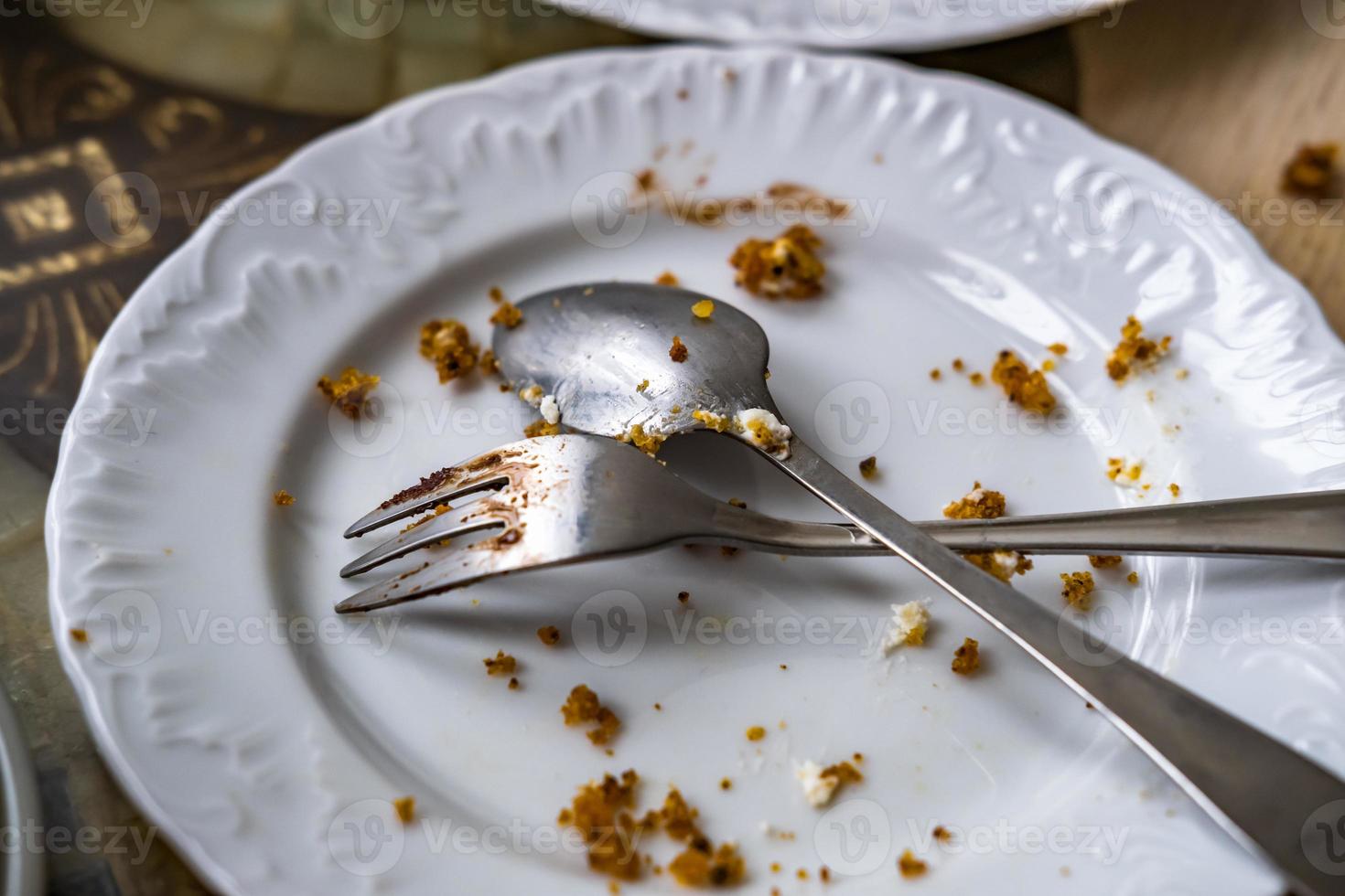 prato sujo vazio com colher e garfo na mesa depois do café da manhã foto