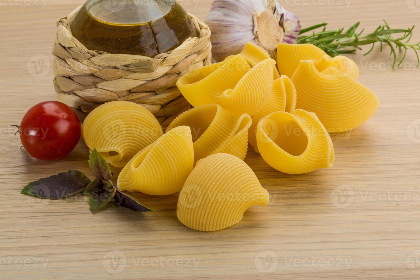 macarrão cru em fundo de madeira foto