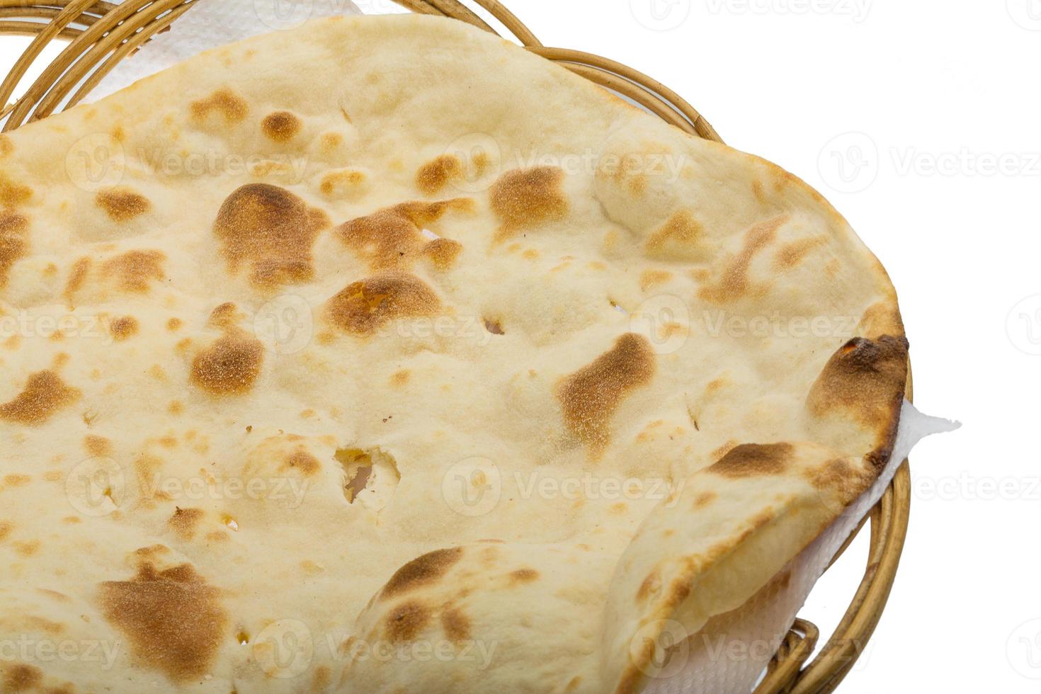 naan simples em uma cesta no fundo branco foto