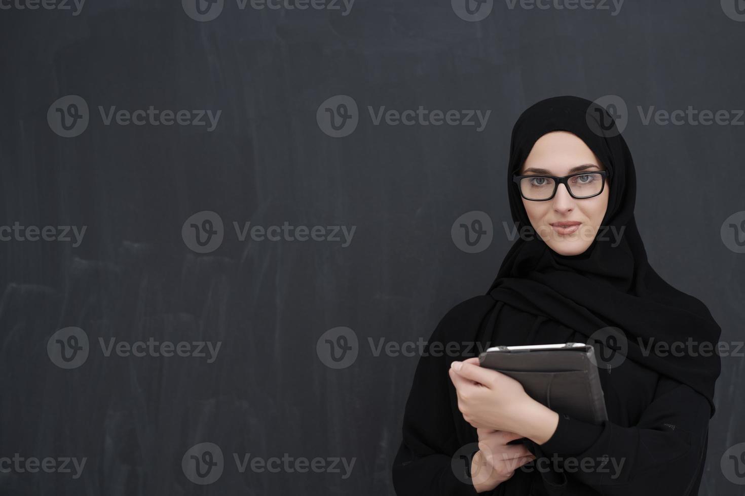 jovem empresária árabe em roupas tradicionais ou abaya segurando computador tablet foto