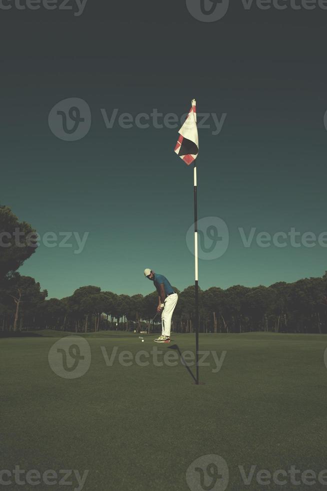 jogador de golfe acertando tiro em dia ensolarado foto