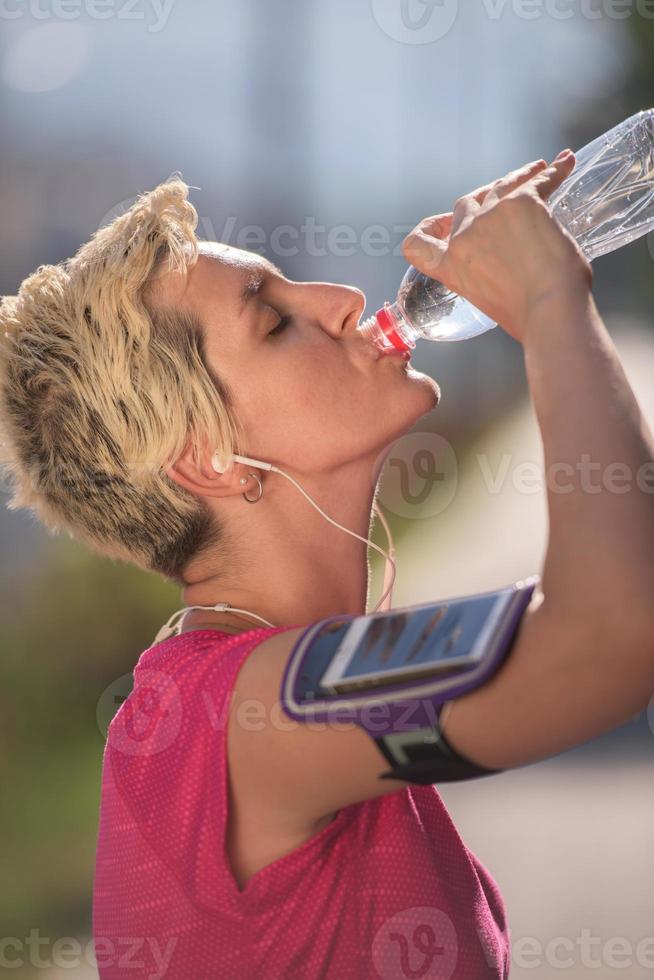 mulher bebendo água depois de correr foto