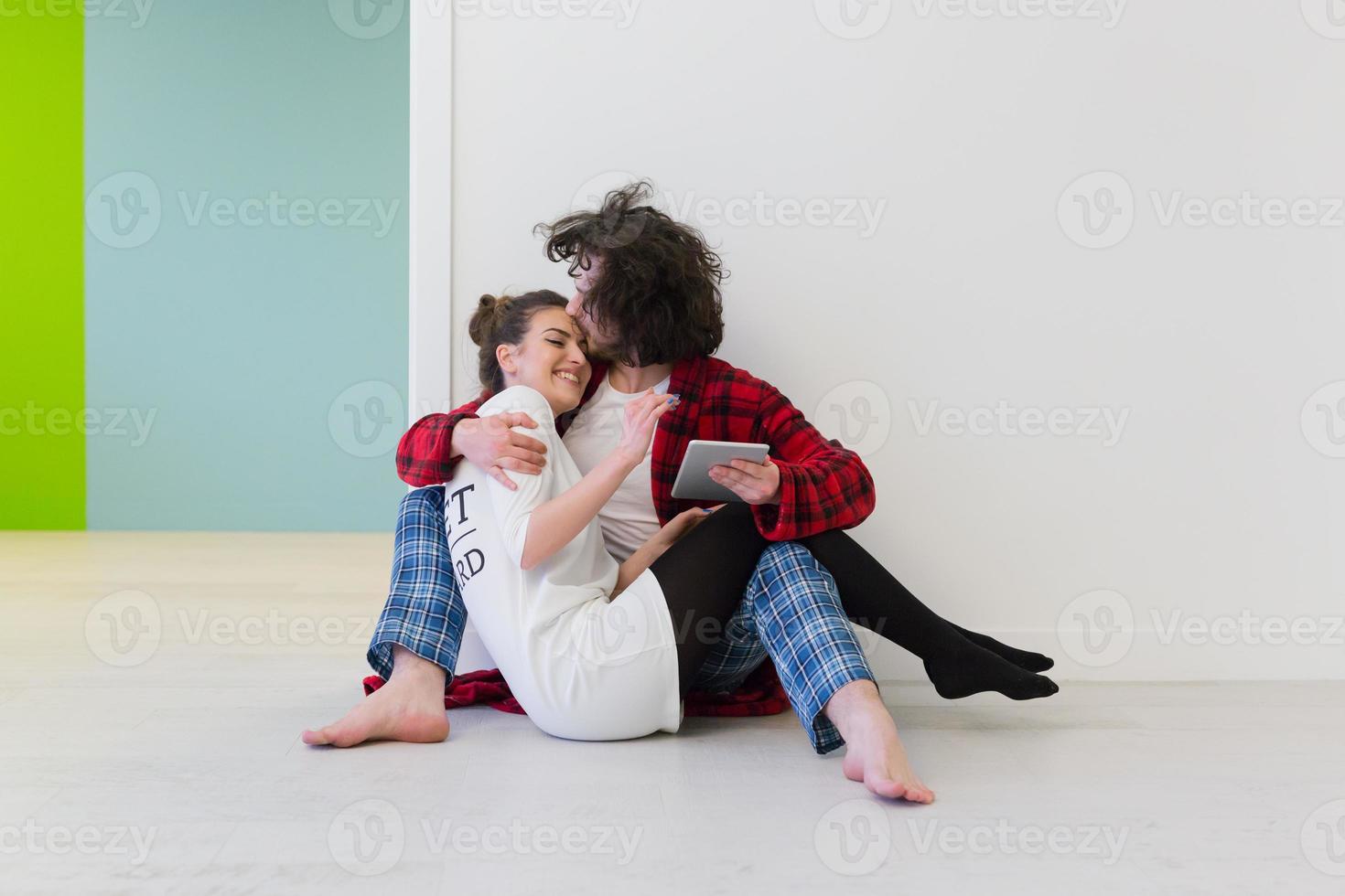 jovem casal usando tablet digital no chão foto