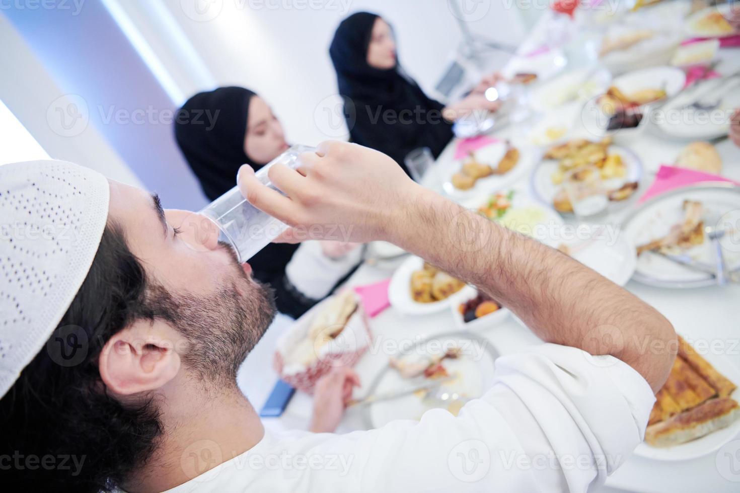 família muçulmana jantando iftar bebendo água para quebrar a festa foto