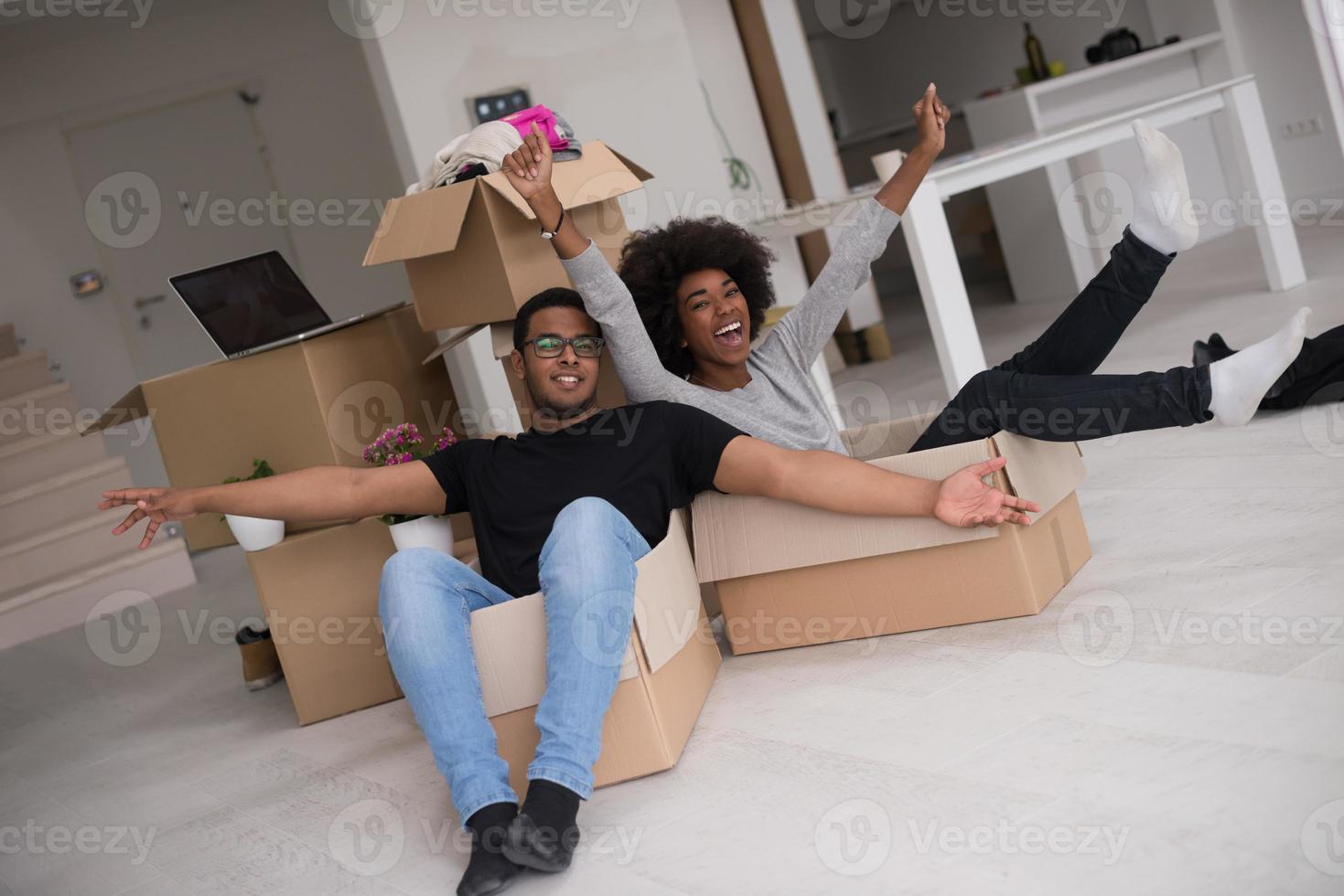 casal afro-americano brincando com material de embalagem foto