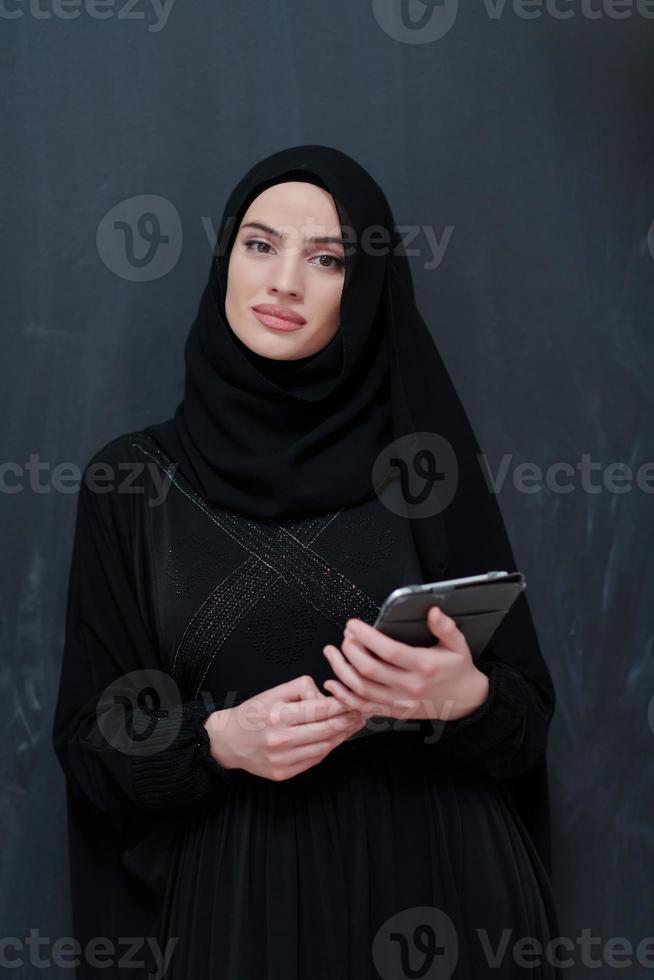 jovem empresária árabe em roupas tradicionais ou abaya com computador tablet foto