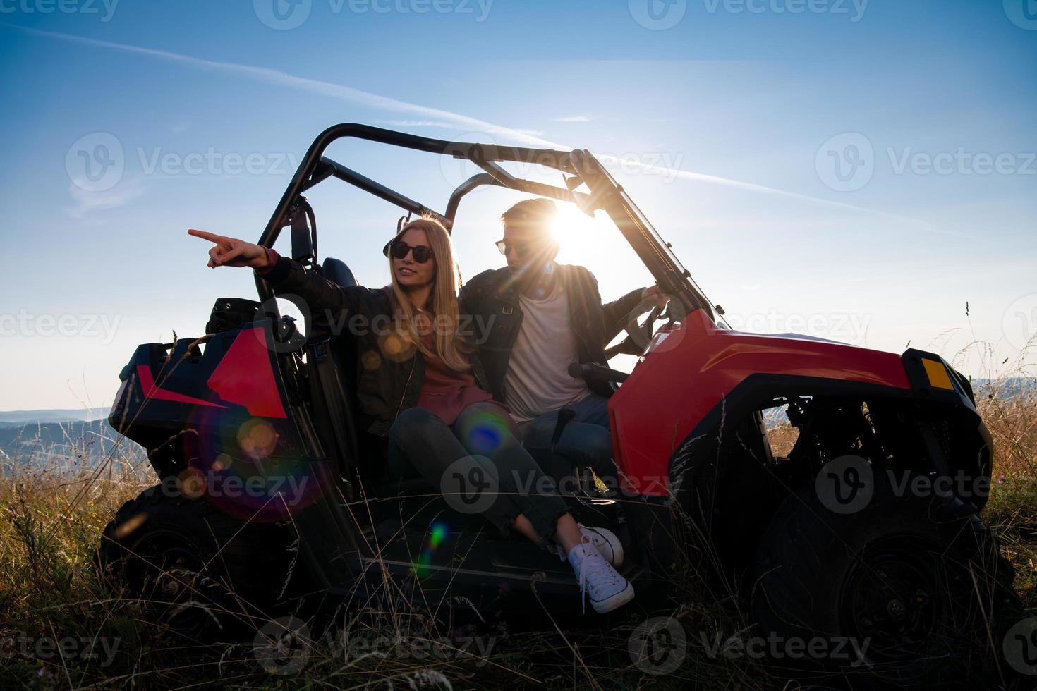 jovem casal dirigindo um carro de buggy off road foto