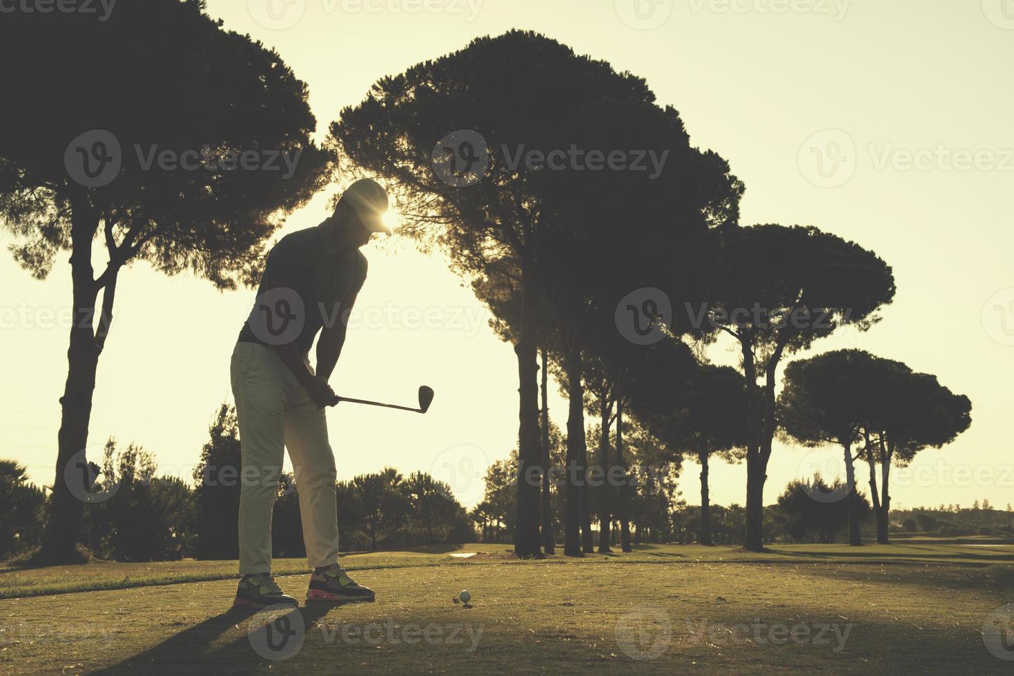jogador de golfe acertando tiro foto