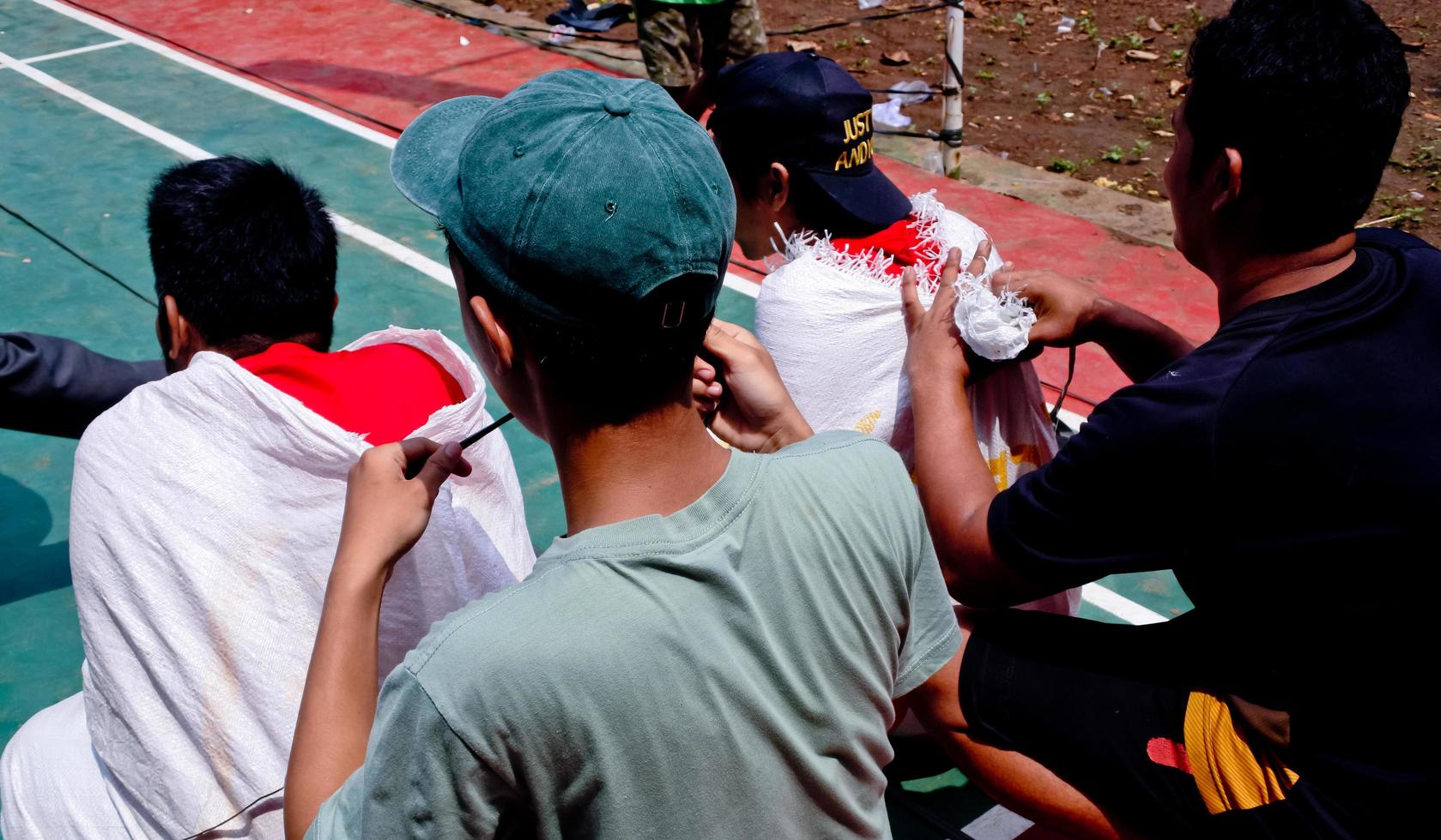 várias competições para comemorar o dia da independência da indonésia foram realizadas de forma simples, mas ainda animada. corrida de saco, competição de comer biscoito, cabo de guerra, competição de escalada areca. foto