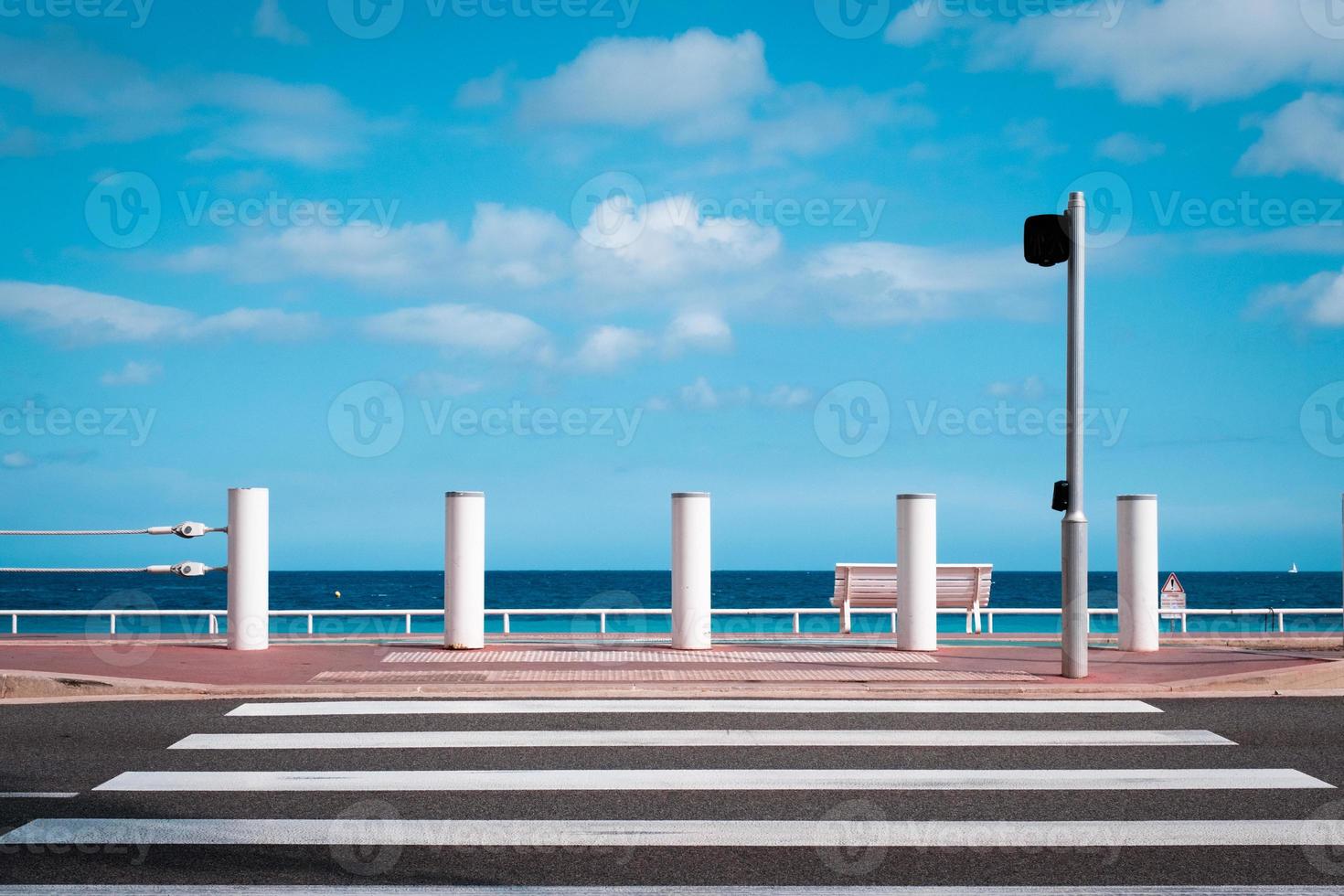 faixa de pedestres para o passeio na praia cote d'azur em nice, frança, viaje para o mar azul, fundo de verão com nuvens. foto