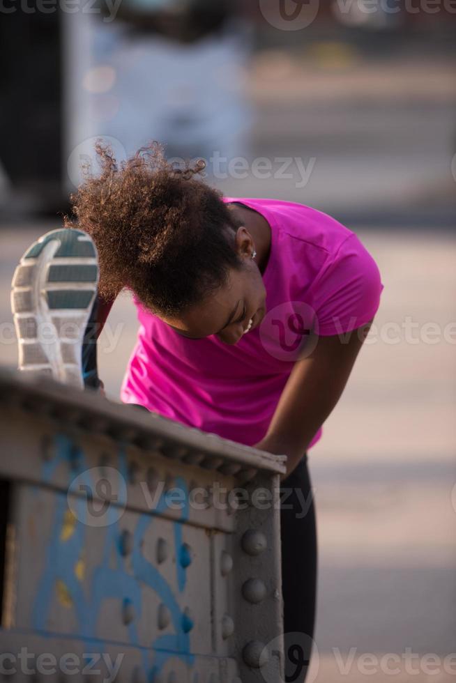 mulher afro-americana fazendo aquecimento e alongamento foto